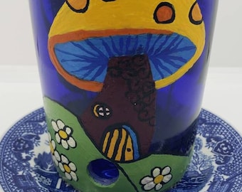 Blue Bird feeder made of recycled wine bottle. Hand painted with two feeding holes with unique painted designs on each side. Saucer attached