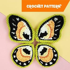 May include: Four crochet butterfly wings in black, white, yellow, and orange, with a green border, arranged to form a butterfly shape. The words "CROCHET PATTERN" are in an orange rectangle at the top. The background is split between pink and yellow.