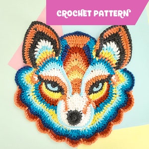 May include: Crochet pattern for a colorful wolf face. The wolf has blue, orange, yellow, white, and gray yarn. The pattern is called "Crochet Pattern".