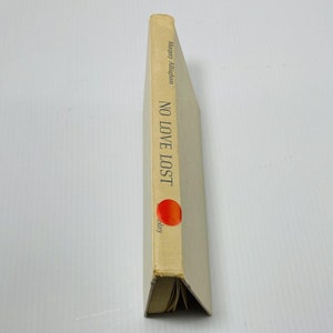 Puede incluir: Un libro de bolsillo vintage titulado "No Love Lost" de Margery Allingham. La portada del libro es de color crema con texto negro y un círculo rojo con un diseño rojo y naranja.