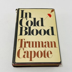 May include: A vintage paperback book with a yellow cover and black text. The title is "In Cold Blood" by Truman Capote.