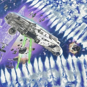 Op de afbeelding: Een tie-dye ontwerp met een ruimteschip dat groene lasers afvuurt, met andere ruimtevaartuigen en ruimtepuin. De achtergrond heeft een blauw en paars tie-dye patroon, met een paar explosies. De afbeelding is een Star Wars thema.