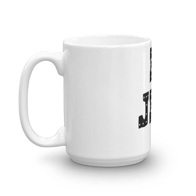 May include: White ceramic coffee mug with a black graphic of the word "Just" in a stylized font.