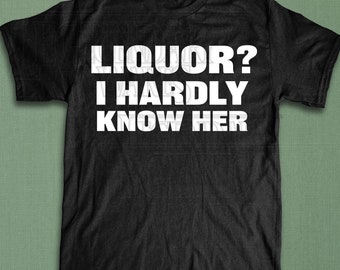 Puede incluir: Camiseta negra con el texto blanco "LIQUOR? I HARDLY KNOW HER." La camiseta tiene mangas cortas y cuello redondo. El nombre de la marca "LEGENDARY WARES" está impreso en blanco en la esquina inferior derecha.
