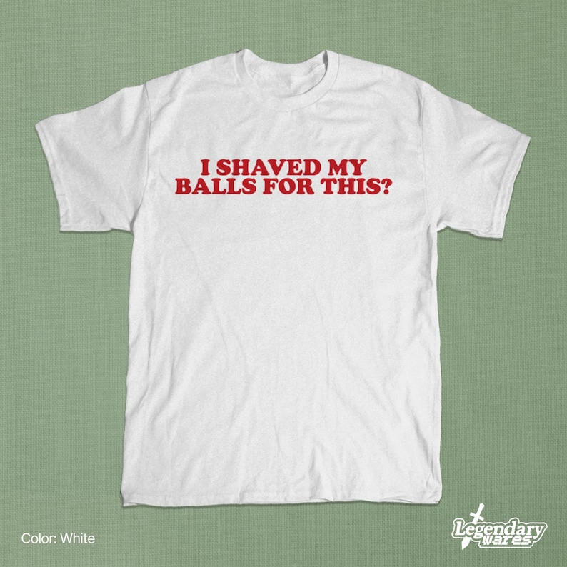 Op de afbeelding: Wit T-shirt met de rode tekst "I SHAVED MY BALLS FOR THIS?". Het shirt heeft korte mouwen en een ronde hals. Het Legendary Wares-logo staat rechtsonder.