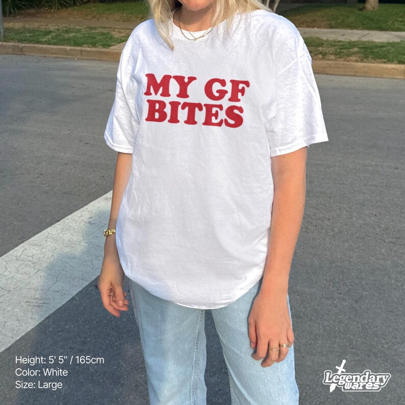 May include: White t-shirt with the red text "MY GF BITES". The shirt is a large size and the model is 5' 5" tall. The shirt is white.