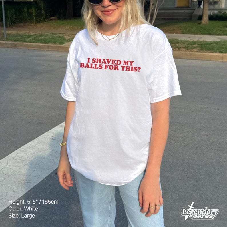 Op de afbeelding: Wit T-shirt met de rode tekst "I SHAVED MY BALLS FOR THIS?". Het shirt is maat large en de persoon op de foto is 165 cm lang. Het shirt is wit.