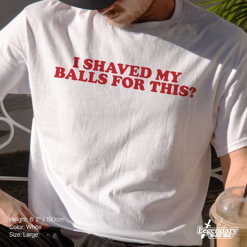 Op de afbeelding: Wit T-shirt met de rode tekst "I SHAVED MY BALLS FOR THIS?". Het shirt is maat large. De persoon op de foto is 190 cm lang. Het shirt is van Legendary Wares.