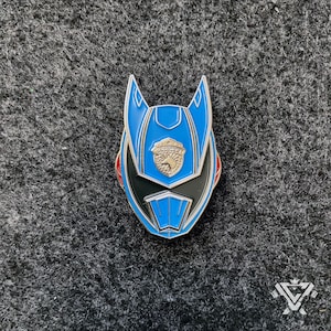 May include: A blue and black enamel pin featuring a stylized helmet with a silver badge. The helmet has a pointed top and a black visor. The badge has a white horse and the word "Power" in a circle.