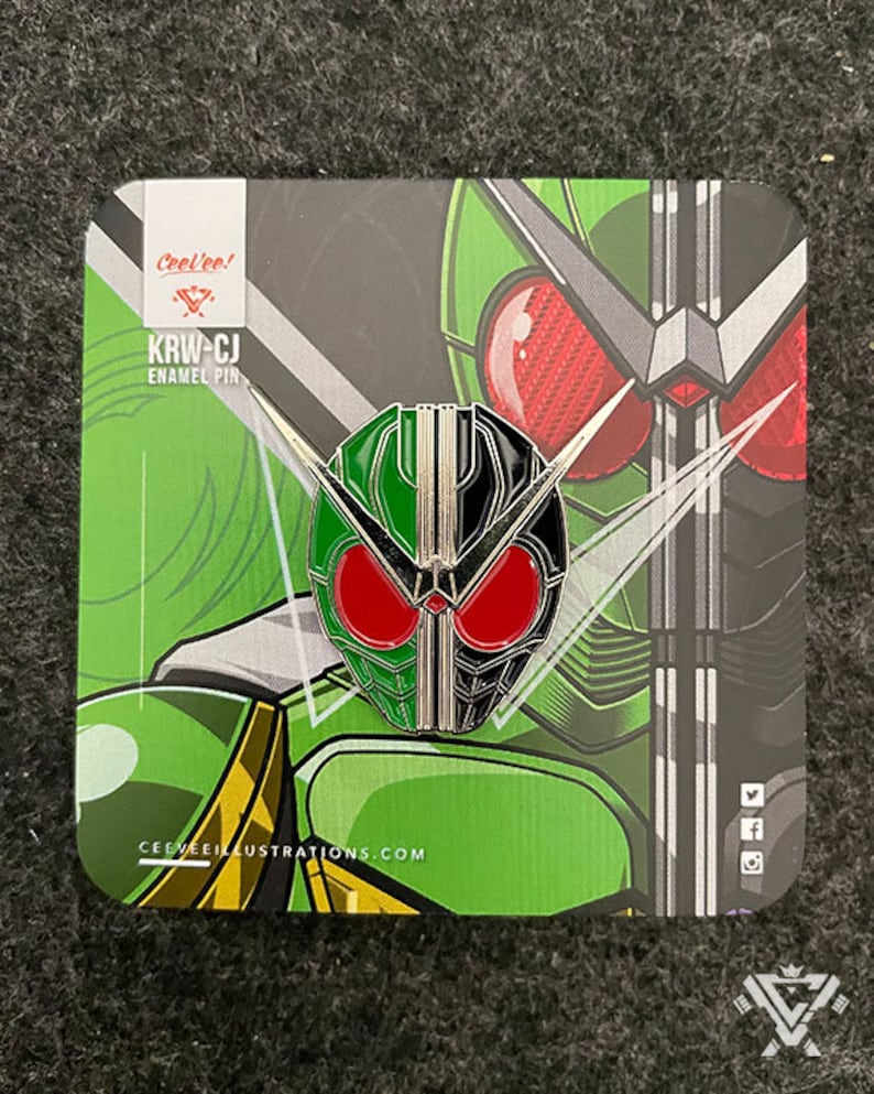 May include: A green and black enamel pin featuring a stylised depiction of a Kamen Rider mask. The pin is on a card with the text "Cool-ee! KRW-CJ Enamel Pin" and the website "CEEVEEILLUSTRATIONS.COM".