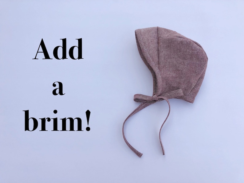 May include: A brown fabric baby bonnet with a tie. The text "Add a brim!" is written on a white background.