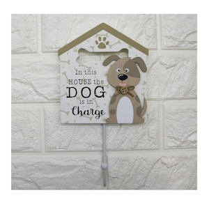 May include: A wooden dog house shaped sign with a cute cartoon dog on it. The sign reads "In this house the dog is in charge".
