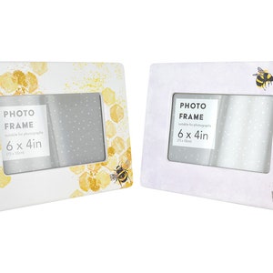May include: Two white photo frames with a bee and honeycomb design on one and a bee and lavender design on the other. Both frames are 6x4 inches.