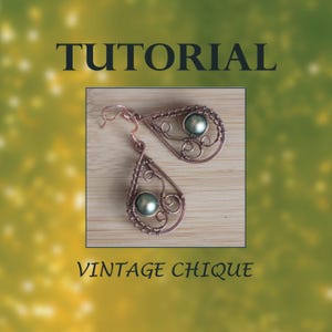 May include: A pair of copper wire earrings with a teardrop shape and a green pearl bead in the center. The earrings are on a wooden surface. The text "TUTORIAL" and "VINTAGE CHIQUE" are visible in the image.