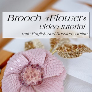 Könnte beinhalten: Eine Brosche in Form einer rosa Blume mit einem Perlenmittelpunkt und goldenen Blättern. Die Brosche ist handgefertigt und es gibt ein Video-Tutorial mit englischen und russischen Untertiteln.