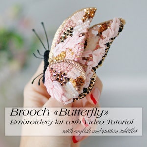 Könnte beinhalten: Eine rosa und goldene Schmetterlingsbrosche mit Perlenakzenten. Die Brosche ist ein Stickset mit einem Video-Tutorial, mit englischen und russischen Untertiteln.