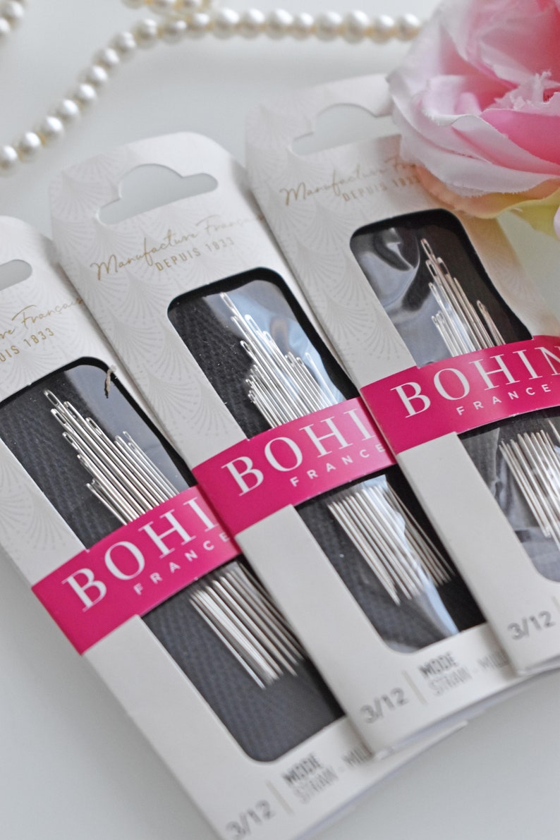 May include: Three packages of Bohin sewing needles, size 3/12, with the text "Manufacture Fran&ccedil;aise Depuis 1833" on the front. The packages are white with pink and black accents.