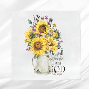 May include: Square wall art featuring a watercolor bouquet of sunflowers, daisies, and purple flowers in a white pitcher. The text reads "Be still and know that I am GOD" from Psalm 46:10.