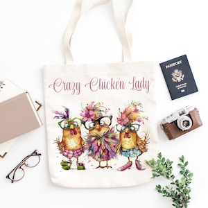 May include: A white canvas tote bag with the text "Crazy Chicken Lady" printed in pink. Three cartoon chickens wearing glasses and flowers are depicted on the bag.