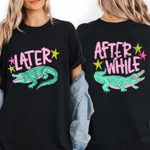 May include: Black t-shirts with a teal alligator graphic and the phrases "LATER" and "AFTER WHILE" in pink lettering. The design includes yellow and pink star accents. The shirts are a casual style.