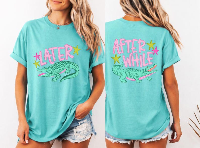 May include: Turquoise t-shirt with a front graphic of a green alligator and the word "LATER" in pink. The back of the shirt features the words "AFTER WHILE" and a similar alligator design. The design includes yellow and pink stars.
