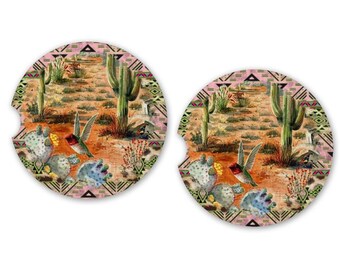 Puede incluir: Dos posavasos redondos y coloridos con una escena del desierto que presenta cactus, un colibrí y un patrón geométrico. Los posavasos están hechos de corcho y son perfectos para proteger las superficies de los derrames.