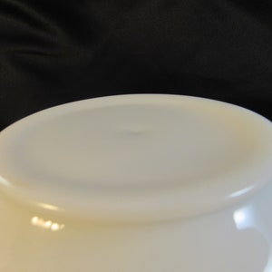 May include: White ceramic bowl with a smooth, glossy finish. The bowl is empty and has a slight curve to the bottom.