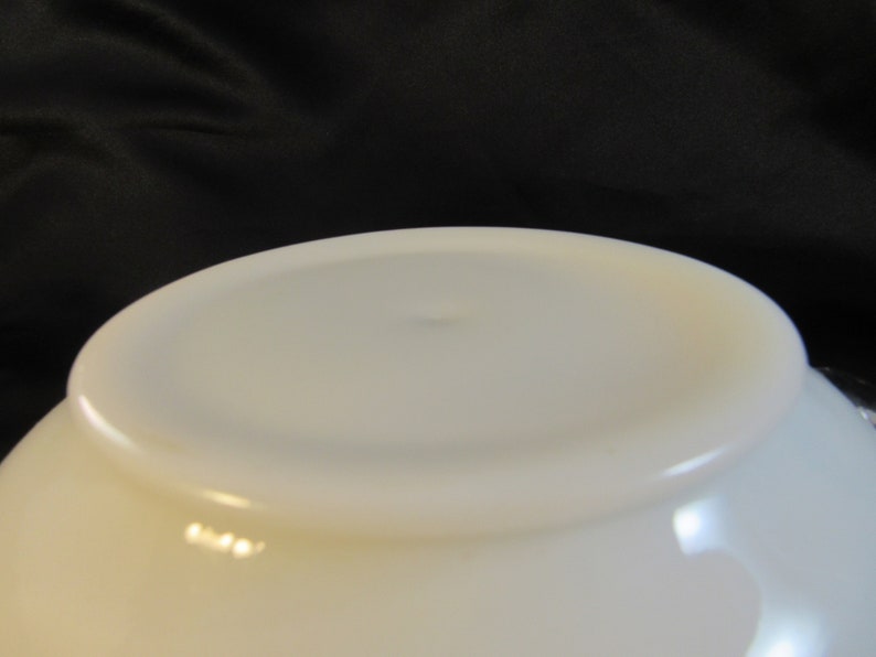 May include: White ceramic bowl with a smooth, glossy finish. The bowl is empty and has a slight curve to the bottom.