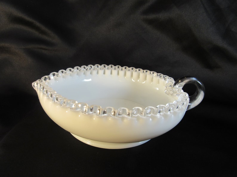 May include: White milk glass bowl with a silver beaded edge and a clear glass handle.