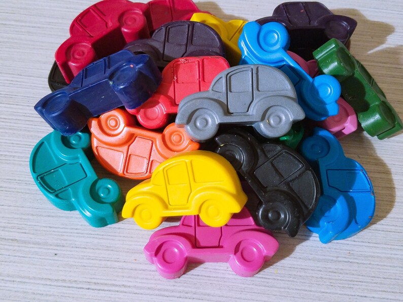 Puede incluir: Un mont&oacute;n de coches de juguete de colores hechos de cera. Los coches son de varios tonos de azul, verde, rojo, amarillo, naranja y morado.