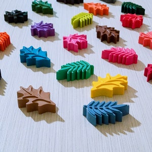 May include: Assortment of colorful leaf-shaped crayons in various shades of green, blue, red, yellow, brown, and purple.