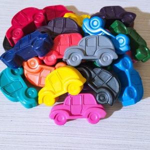 Puede incluir: Una colecci&oacute;n de coches de juguete coloridos hechos de cera. Los coches son de varios tonos de azul, verde, rojo, amarillo, rosa y negro. Los coches est&aacute;n dispuestos en una pila, con algunos de los coches superpuestos.