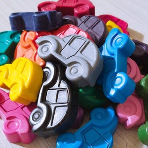 Puede incluir: Un mont&oacute;n de coches de juguete de colores hechos de cera. Los coches son de varios colores, incluyendo rojo, azul, verde, amarillo, naranja y negro. Los coches son todos de diferentes formas y tama&ntilde;os.