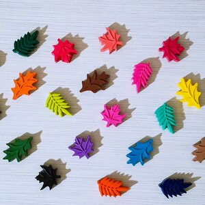 May include: Assortment of colorful leaf-shaped crayons in various shades of green, blue, red, orange, yellow, purple, brown, and black.