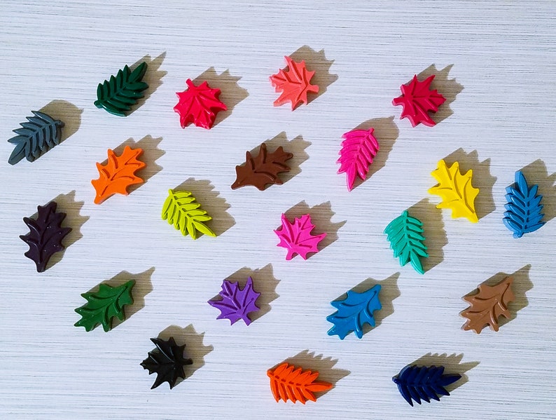 May include: Assortment of colorful leaf-shaped crayons in various shades of green, blue, red, orange, yellow, purple, brown, and black.