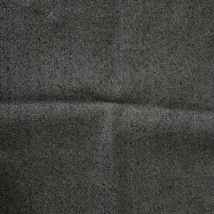 Pu&ograve; includere: Primo piano di un tessuto di colore grigio scuro con una texture e una piega sottile al centro.