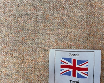 Puede incluir: Primer plano de una tela de tweed beige con una etiqueta blanca que dice "British Tweed" y muestra una bandera del Reino Unido roja, blanca y azul.
