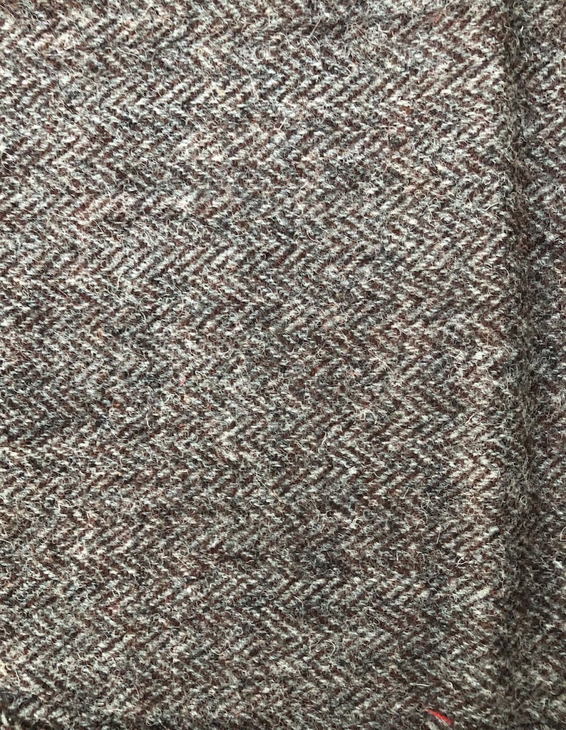 May include: A close-up of a brown and white herringbone patterned fabric. The fabric has a soft, fuzzy texture.