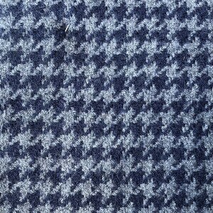 May include: A close-up of a blue and white houndstooth patterned fabric. The fabric has a fuzzy texture.