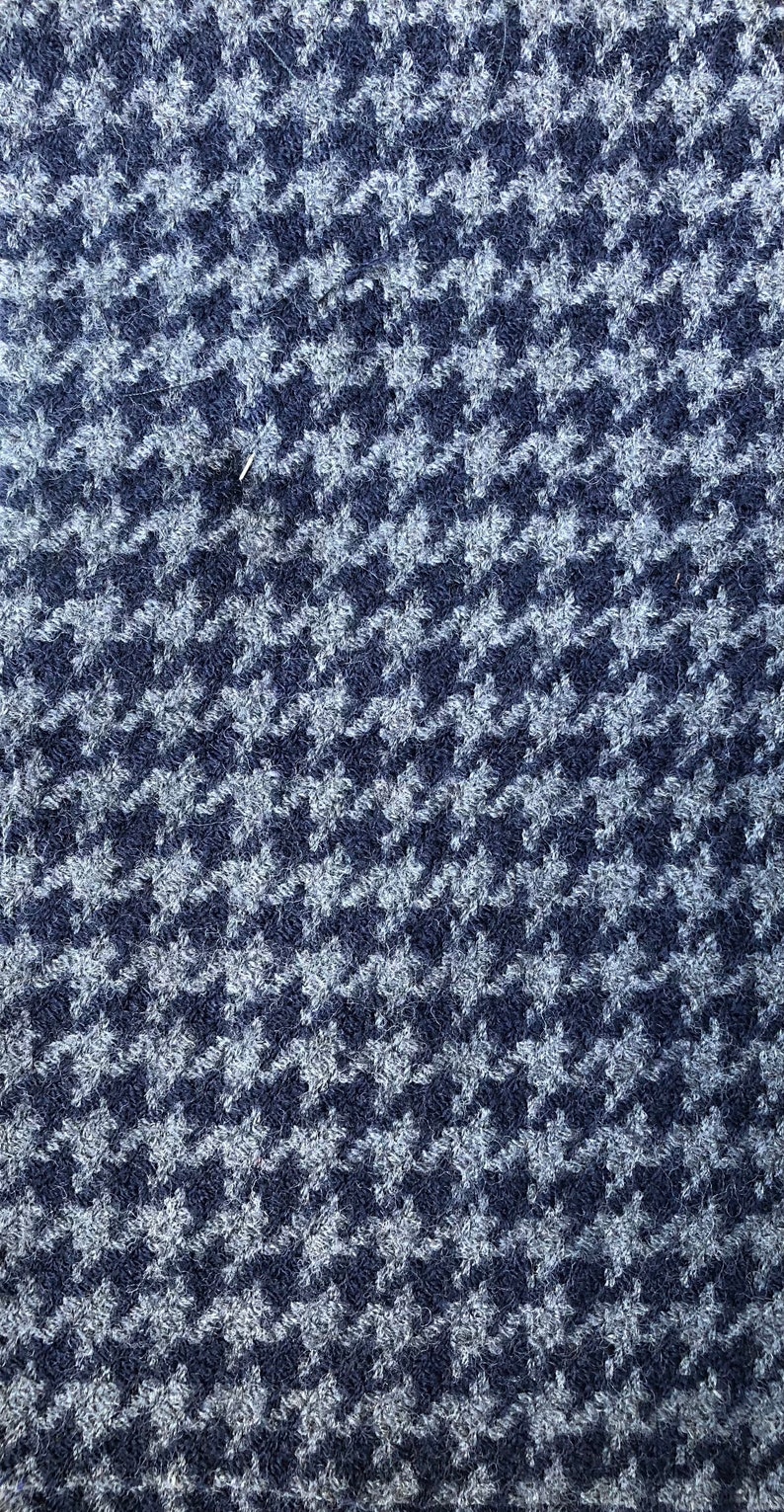May include: A close-up of a blue and white houndstooth patterned fabric. The fabric has a fuzzy texture.