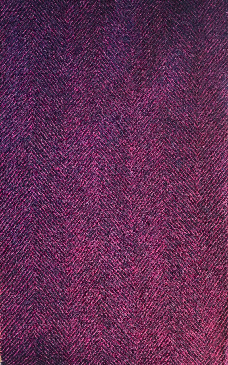 May include: A close-up of a dark purple fabric with a herringbone pattern.