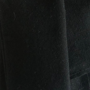 May include: A close-up of a black fabric with a smooth texture.