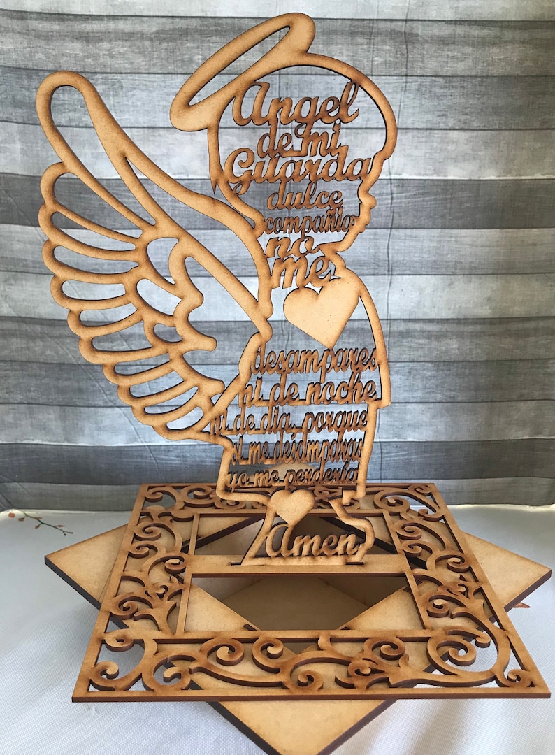 Puede incluir: Una figura de &aacute;ngel de madera con halo y alas. El &aacute;ngel sostiene un coraz&oacute;n y tiene un mensaje escrito en &eacute;l que dice: "Angel de mi Guarda dulce companio no me desampares ni de noche ni de dia porque si me desmayas yo me perderia Amen".
