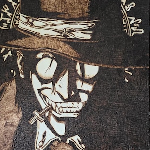 Può includere: Opera d'arte pirografata raffigurante un personaggio stilizzato con cappello a cilindro, pendente a croce e un ampio sorriso. L'immagine è resa in tonalità marroni e nere, con dettagli intricati.