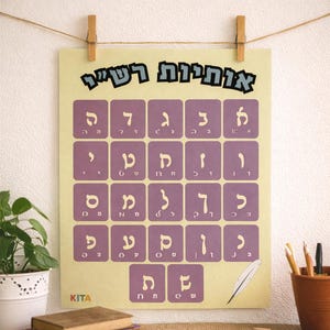 May include: A poster with Hebrew letters in purple squares, arranged in rows. The title "אותיות רש"י" is at the top. The poster is hanging with clothespins. A potted plant and pencils are in the background.