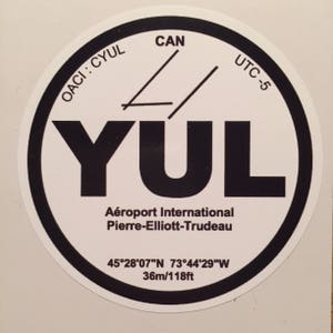 May include: A black and white circular sticker with the text "OACI: CYUL CAN UTC-5 YUL Aéroport International Pierre-Elliott-Trudeau 45°28′07″N 73°44'29"W 36m/118ft".