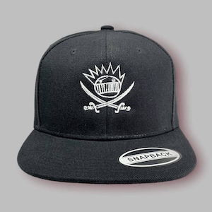 May include: Black baseball cap with a white embroidered logo of a cartoon face with a crown and crossed swords. The logo says "Fun." The cap has a black "Snapback" label on the back.