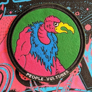 May include: A round, green patch with a black border. The patch features a pink and blue cartoon vulture with the text "PEOPLE VULTURES" at the bottom.