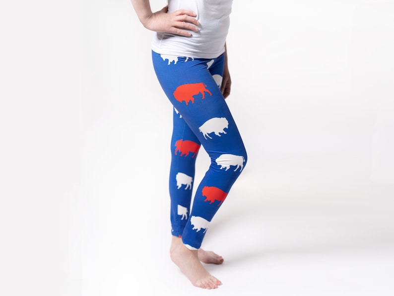 May include: Blue leggings with a pattern of white and red buffalo silhouettes.