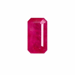 May include: A vibrant, deep pinkish-red gemstone cut into a rectangular emerald shape. The stone features a faceted surface with sharp, clean edges and a polished finish, displaying internal clarity and a bright, reflective light refraction.
